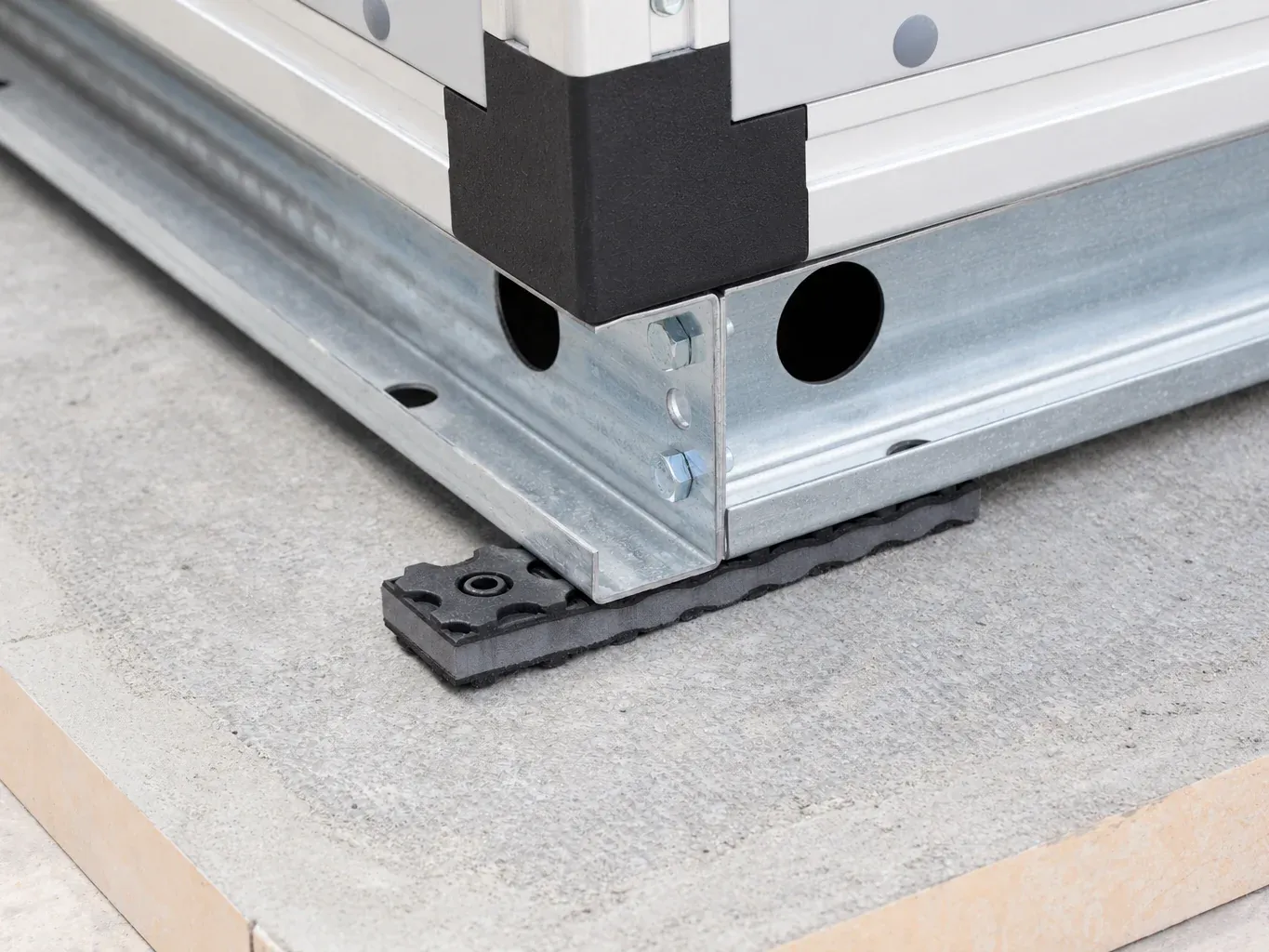 Corner of an air handling unit’s base frame on an API-MC modular pad, with its copolymer layer between the rubber