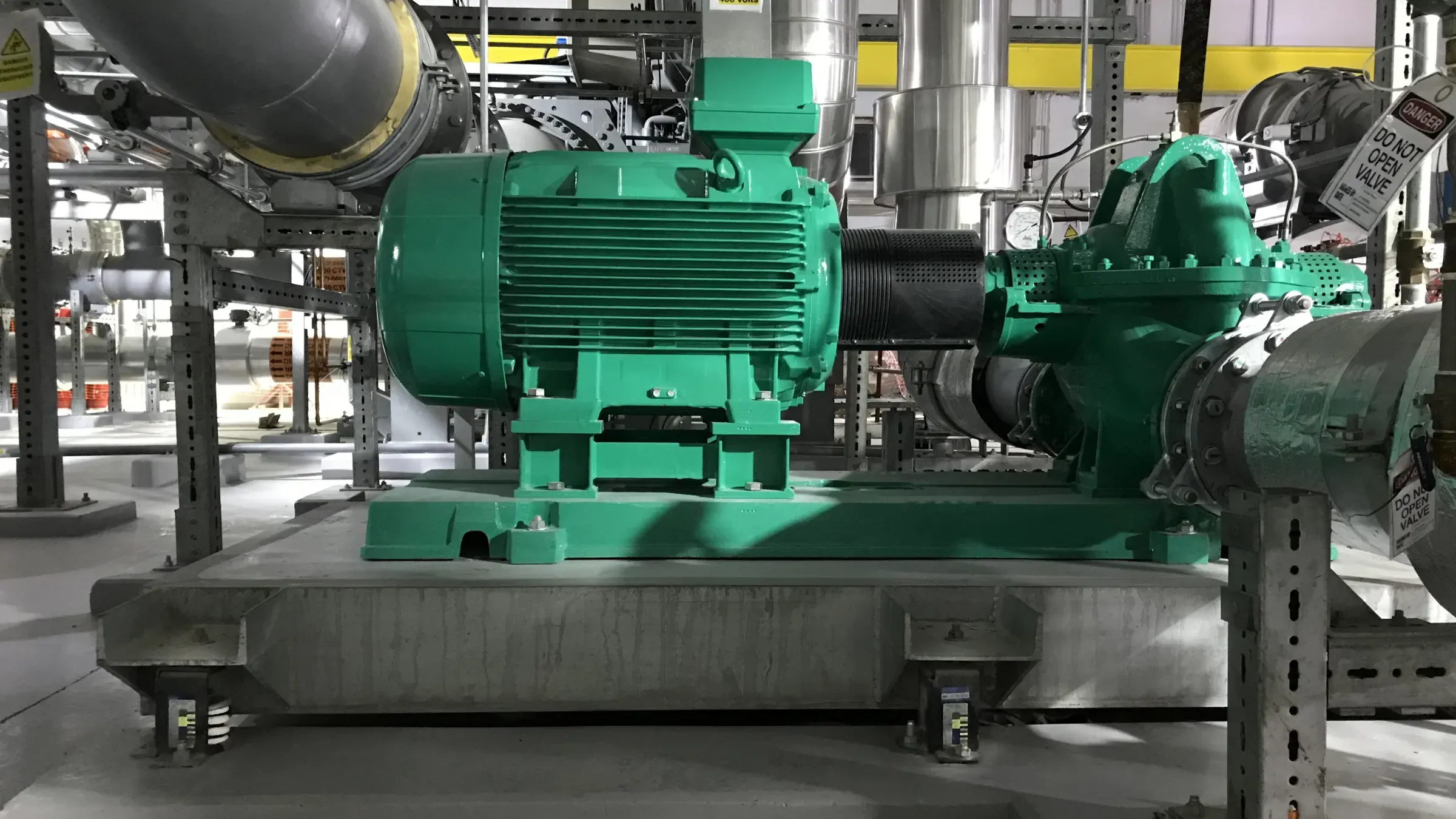 Split-case chilled water pump on a concrete inertia base supported by spring isolators, in a plant room at Bahrain International Airport