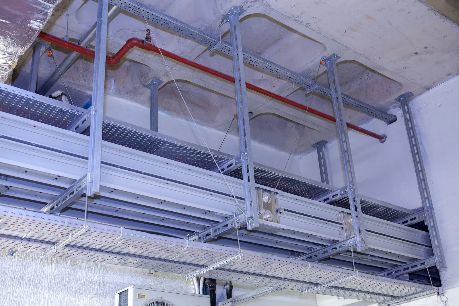 Busbar trunking and cable trays on channel trapezes with seismic cable braces, sprinkler piping above