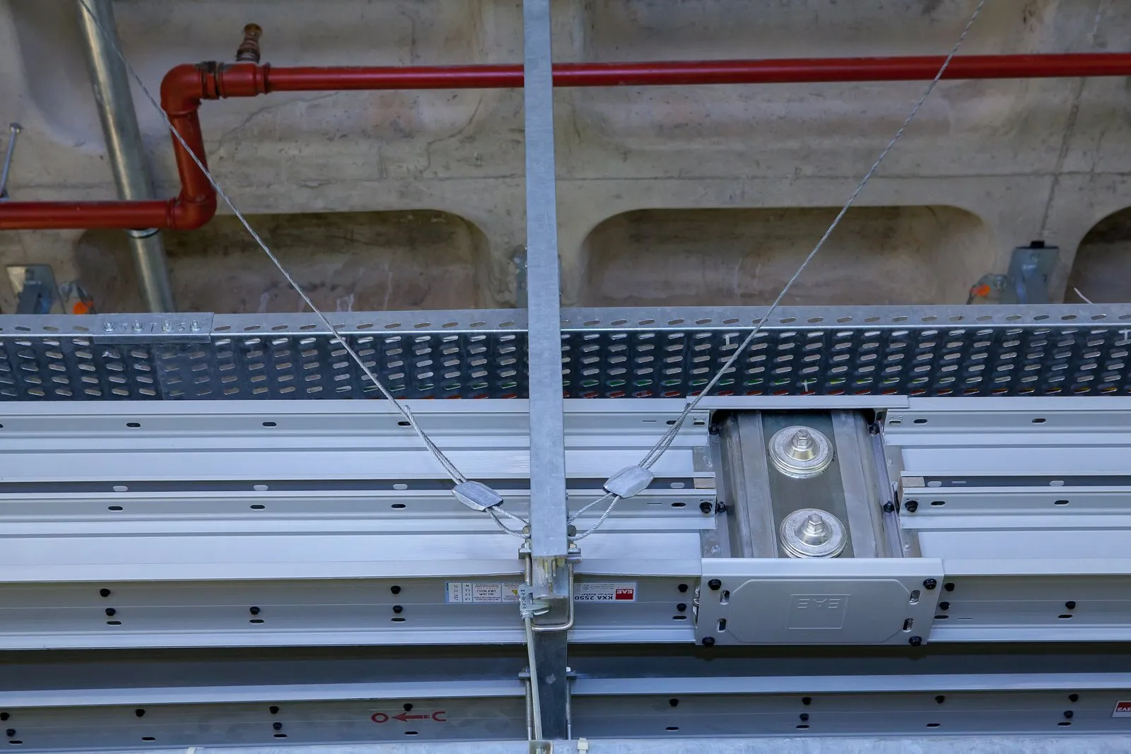 Close-up of two seismic cable braces fixed to a busbar trapeze hanger