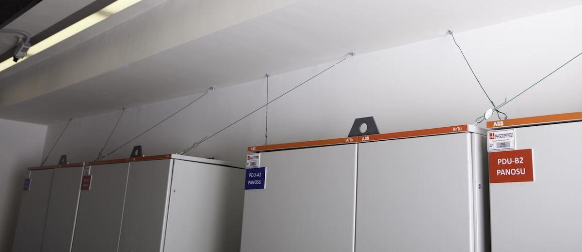 Wire-rope seismic restraints securing the tops of PDU and switchgear cabinets