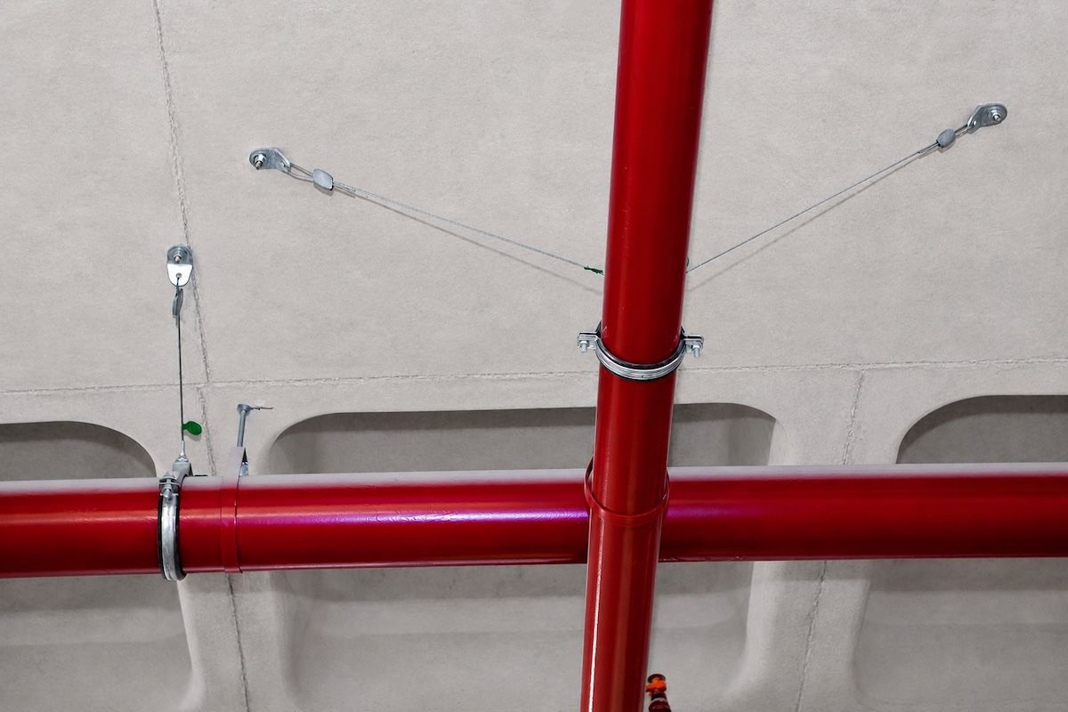 Cable-braced fire-protection pipework under a concrete soffit